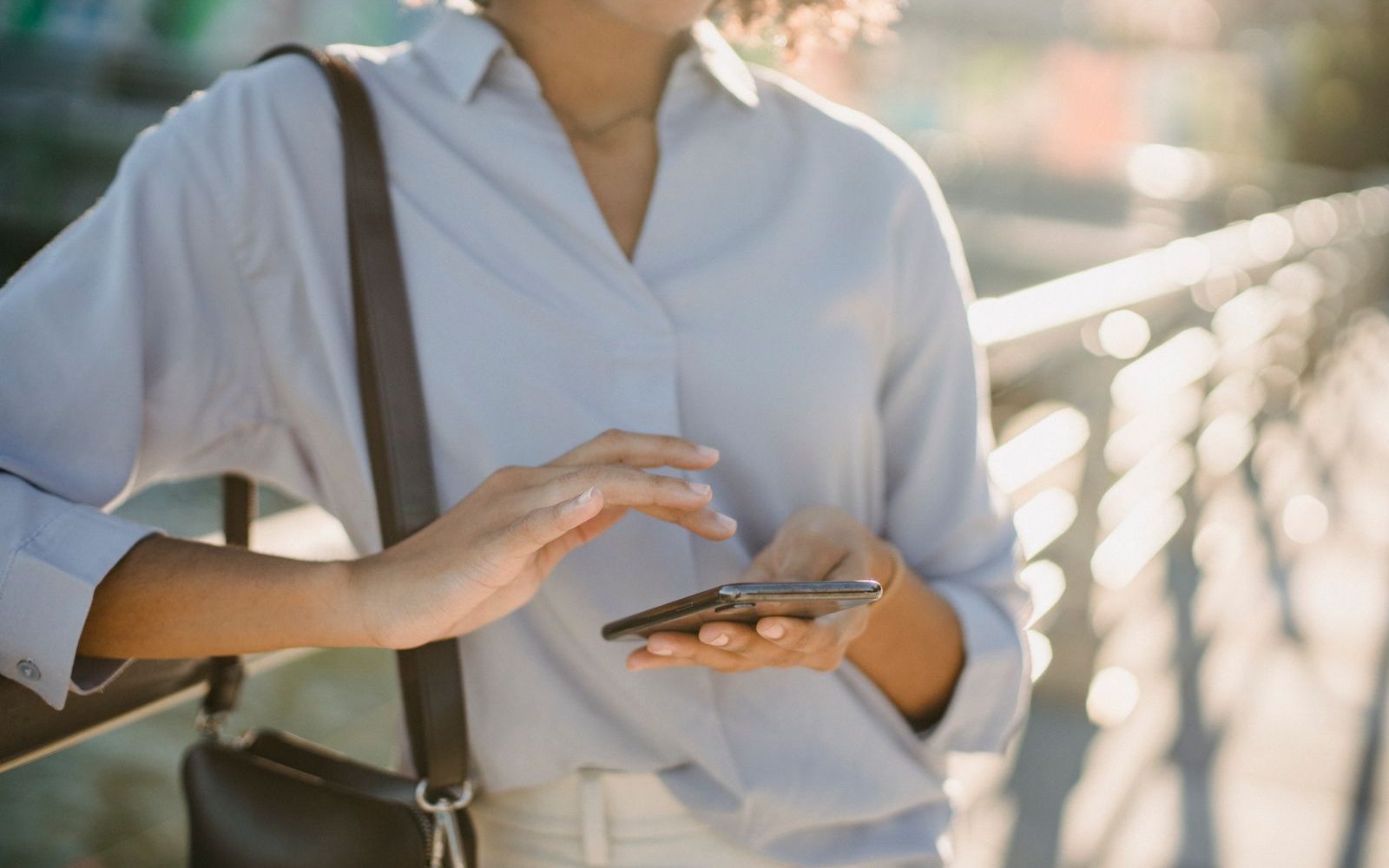 A woman sending money from her phone while walking outdoors